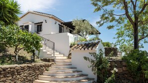 Un bâtiment blanc avec un escalier en pierre menant à un balcon.