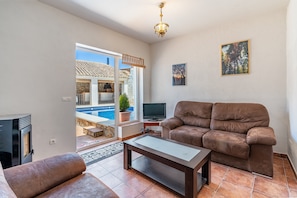 Ein Wohnzimmer mit einer Couch, einem Fernseher und einem Kamin.
