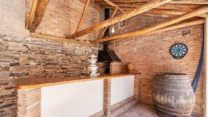 A rustic kitchen with a wooden counter, a large barrel, and a dartboard.