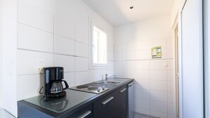 A modern kitchen with a coffee maker, sink, and dishwasher.
