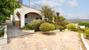 A modern house with a stone patio, a covered entrance, and a view of the surrounding landscape. - Holiday Home "Villa Matteo Suite" with Sea View, Shared Pool and Wi-Fi (Perd'e Sali CA)