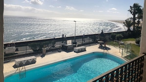 A pool with a view of the ocean, a fenced deck area, and a clear sky. - Holiday Home 'Panoramic Ocean View' with Shared Pool, Wi-Fi and Air Conditioning (Playa del Inglés)