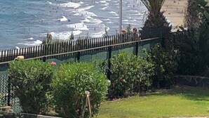 A coastal view with a beach, palm trees, and a fence. - Holiday Home 'Panoramic Ocean View' with Shared Pool, Wi-Fi and Air Conditioning (Playa del Inglés)