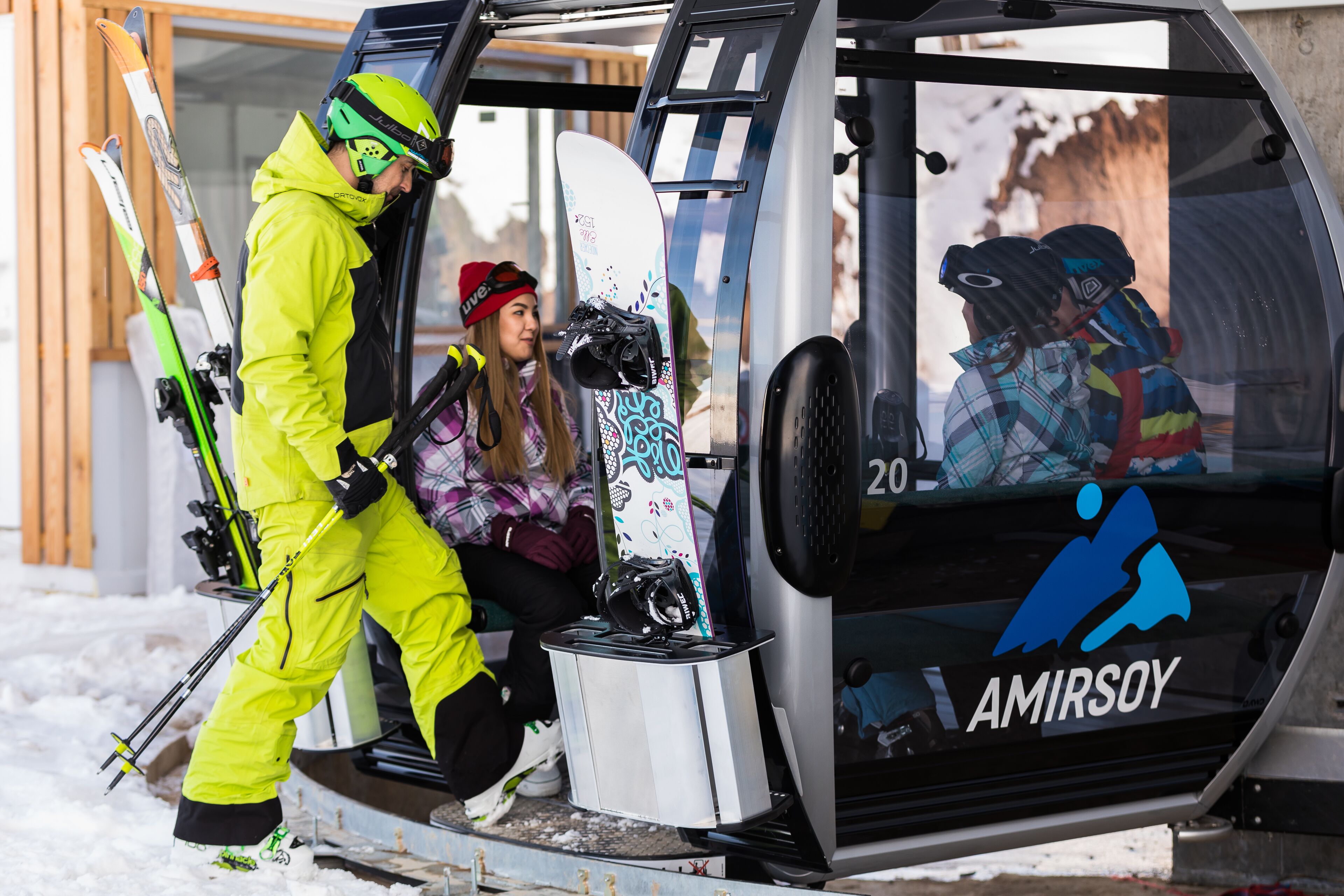 A ski lift cabin with a logo, a snowboard, and skis.