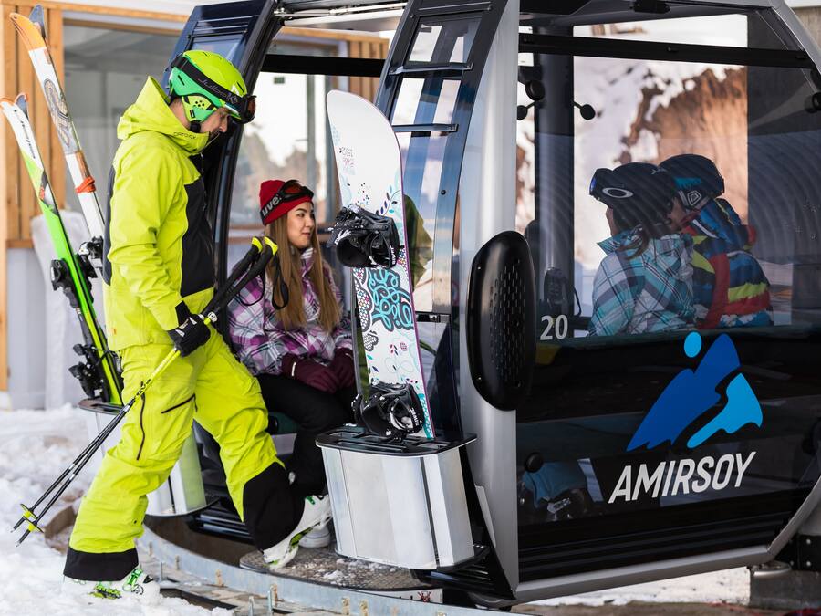 A ski lift cabin with a logo, a snowboard, and skis.