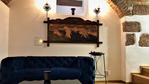 A room with a dark blue sofa, a decorative wall piece, and a small table. - HLH Exklusives Suite Colloseum (Freiburg im Breisgau)