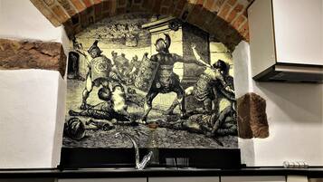 A kitchen with a mural depicting a historical battle scene.