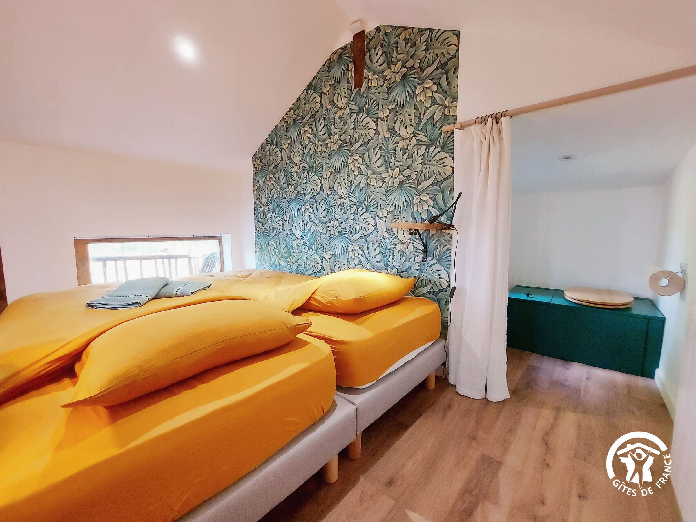 A bedroom with a bed, a wooden headboard, a window, and a green cabinet.