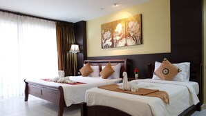 A hotel room with two beds, a large painting on the wall, and a window with curtains. - Sea Boss Homestay (Karon)