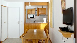 A compact kitchen with wooden cabinets, a microwave, and a coffee maker.