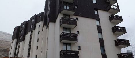 Ein mehrstöckiges Hotel mit Balkonen, einer Stein-Fassade und einem Schild mit der Aufschrift 'LES TOMMEUSES'.