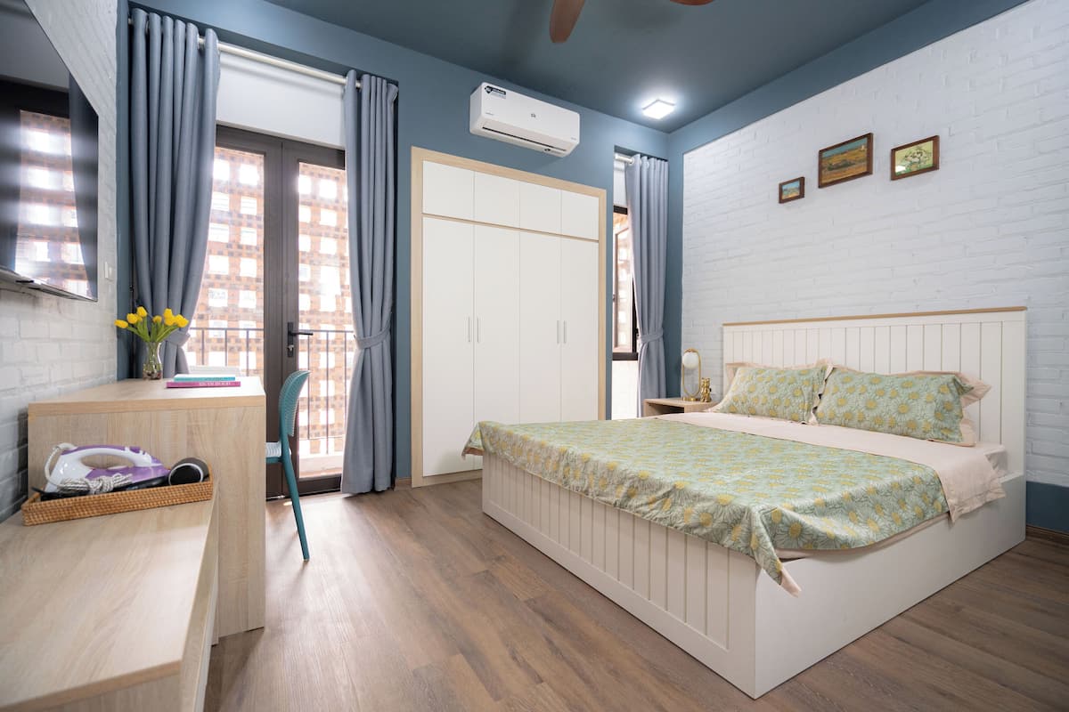 A bedroom with a bed, a desk, a chair, and a wardrobe.