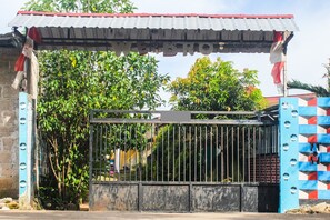 A gated entrance with a metal gate and a sign above it. - Hotel O We Bro Kost (Nginamanu)