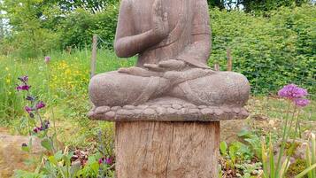 Una statua di Buddha in pietra in un giardino.
