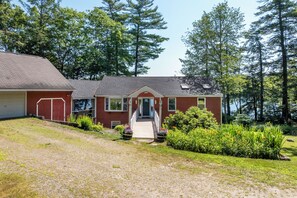 A two-story house with a front porch, a garage, and a well-maintained lawn.