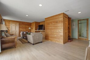A wooden interior with a sofa, TV, and a wooden cabinet.