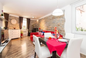 Cozy dining area with a stone wall, large window, and comfortable seating.