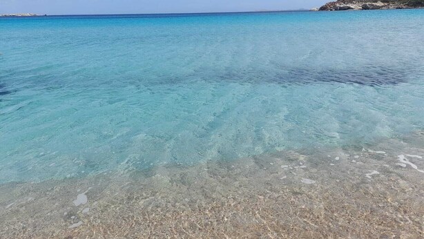 A clear beach with shallow water and a rocky shoreline. - 2 Bedroom Apartment in Palau (Palau)