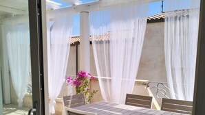An outdoor patio with a table and chairs, covered by a white canopy. - 2 Bedroom Apartment in Palau (Palau)