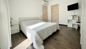 A bedroom with a bed, nightstands, a TV, and a wardrobe. - 2 Bedroom Apartment in Palau (Palau)