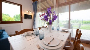 A dining table set with plates, cutlery, and a vase of purple flowers. - Il Podere del Bardo (Puegnago del Garda)