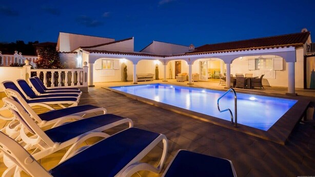 A swimming pool with lounge chairs and a covered patio area. - Villa Freesia with heated pool and free air con (Oasis del Sur)