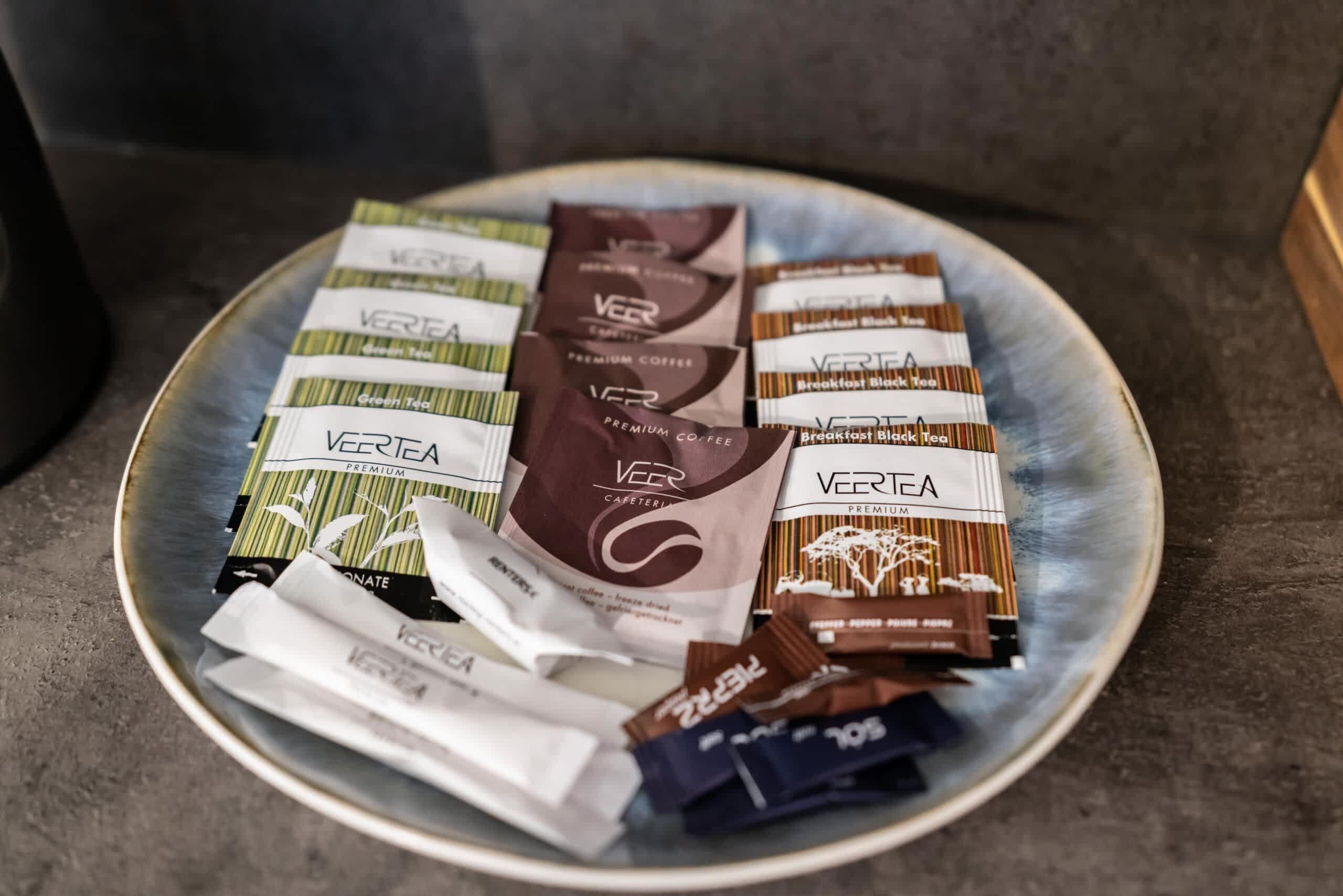 A plate with various branded coffee and tea packets.