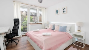 Une chambre à coucher avec un lit, un bureau, une chaise et une fenêtre avec des rideaux.