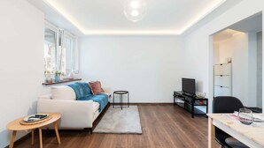 Un salon moderne comprenant un canapé, une table basse, un téléviseur et un coin repas.