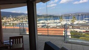 A terrace with a view of a marina and distant hills. - Penthouse near Saint Tropez Cavalaire sur mer Port view, Beach... (Cavalaire-sur-Mer)