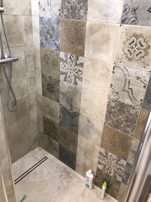 A shower area with a variety of patterned tiles and a handheld showerhead. - Country villa with 19th century trullo 7 minutes from the sea!!! (Racale)