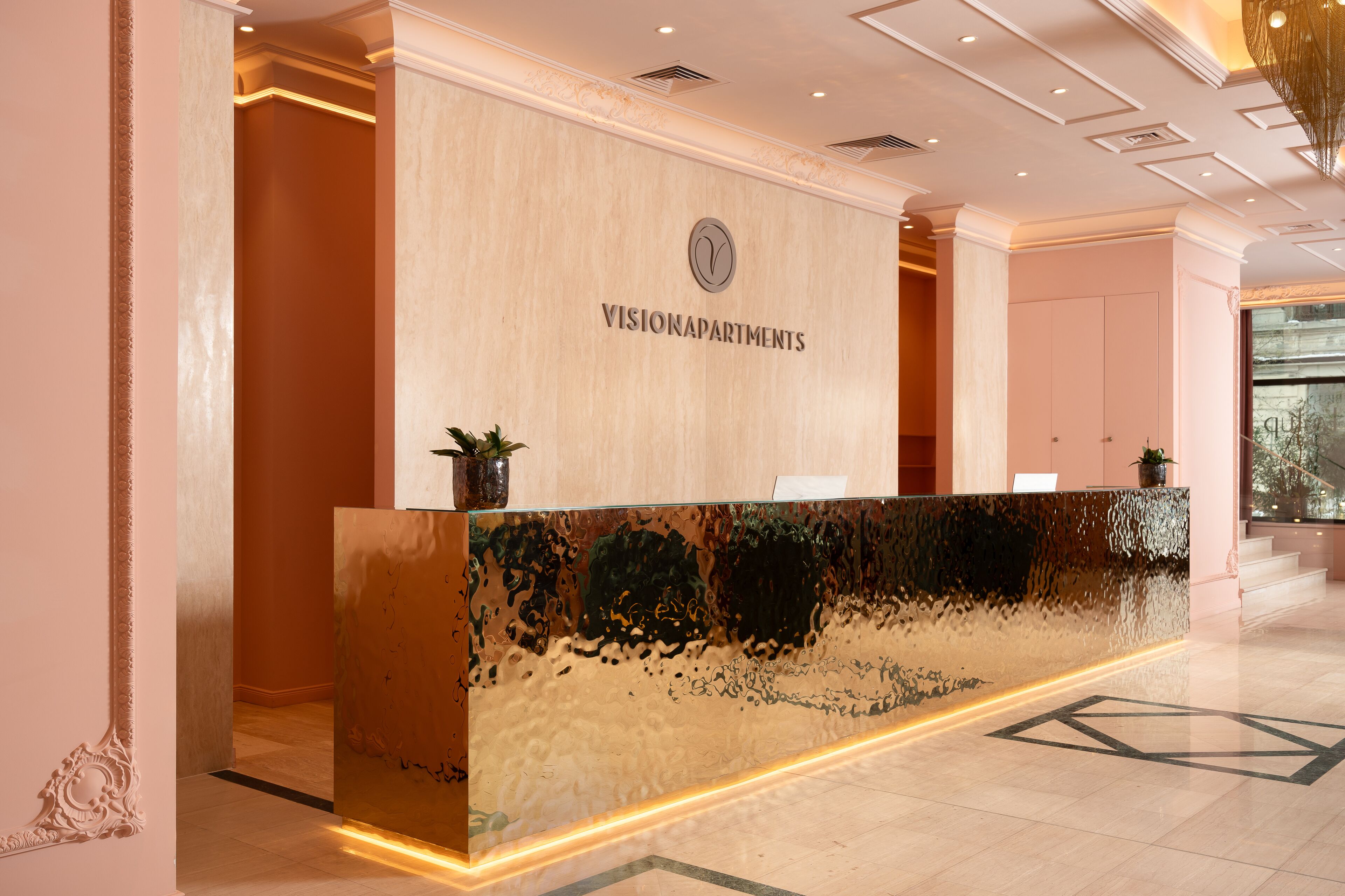 A reception desk with a reflective surface and a logo above it.