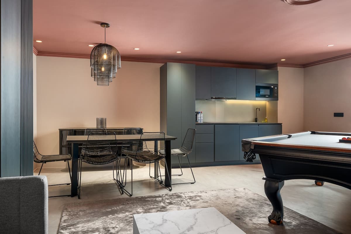 A modern kitchen with a dining area and a pool table.