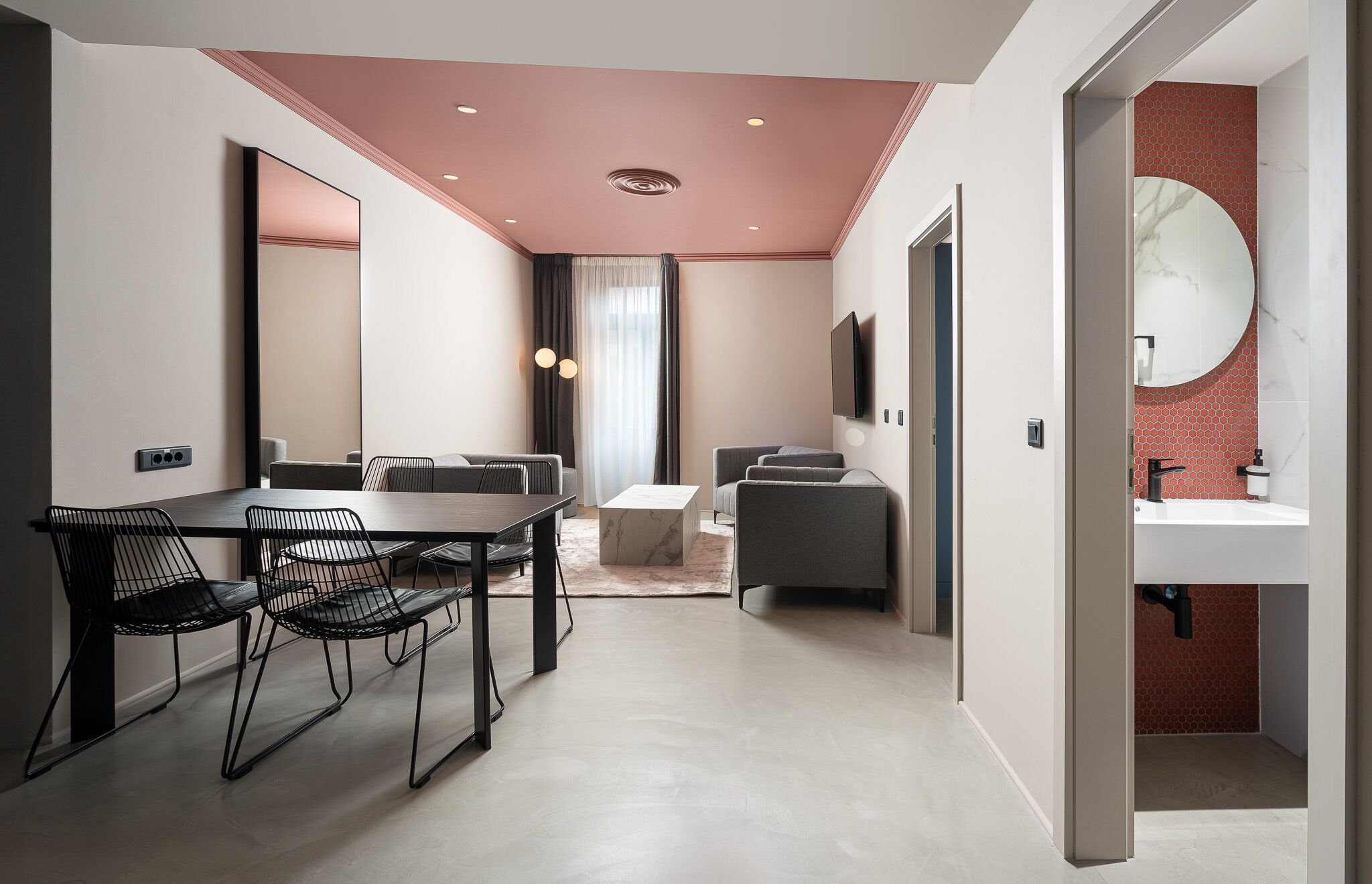 Een moderne hotelkamer met een zithoek, een woongedeelte en een badkamer.