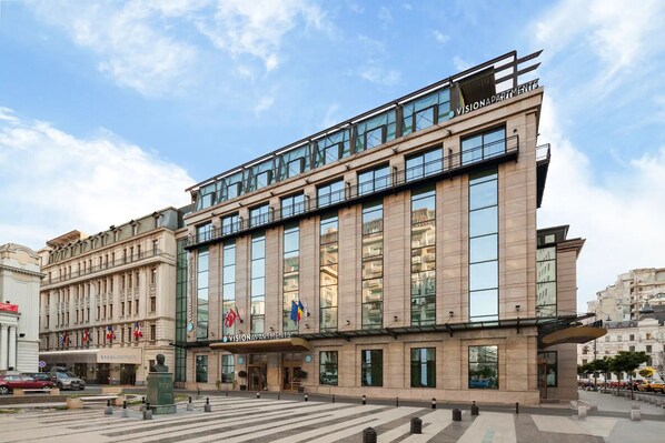 A modern building with multiple floors, large windows, and a prominent entrance.
