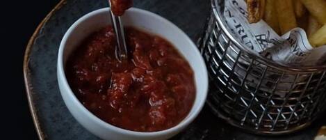 Un plato con un taco, papas fritas y una salsa para mojar.