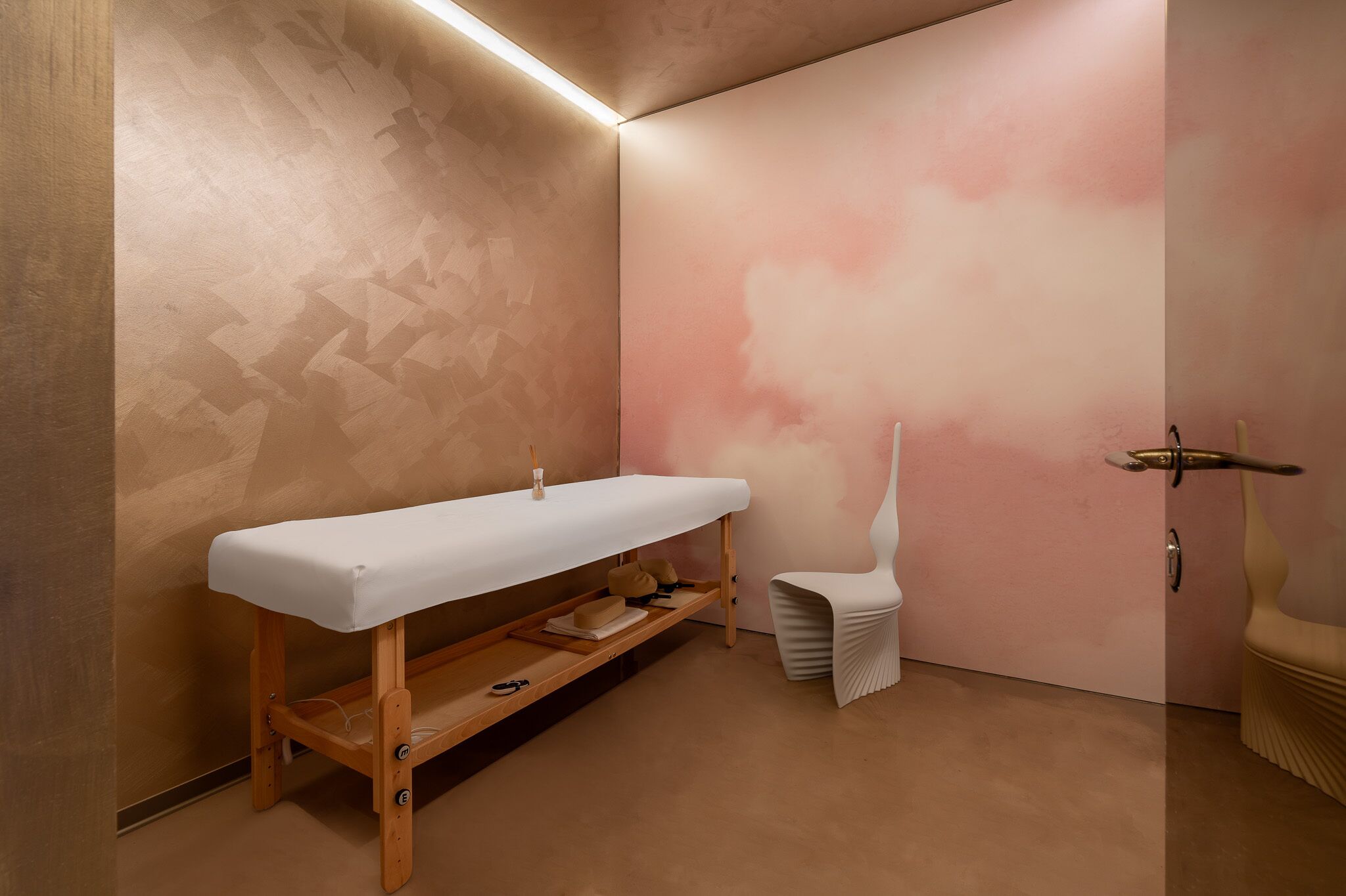 A modern bathroom with a bench, a chair, and a unique wall design.