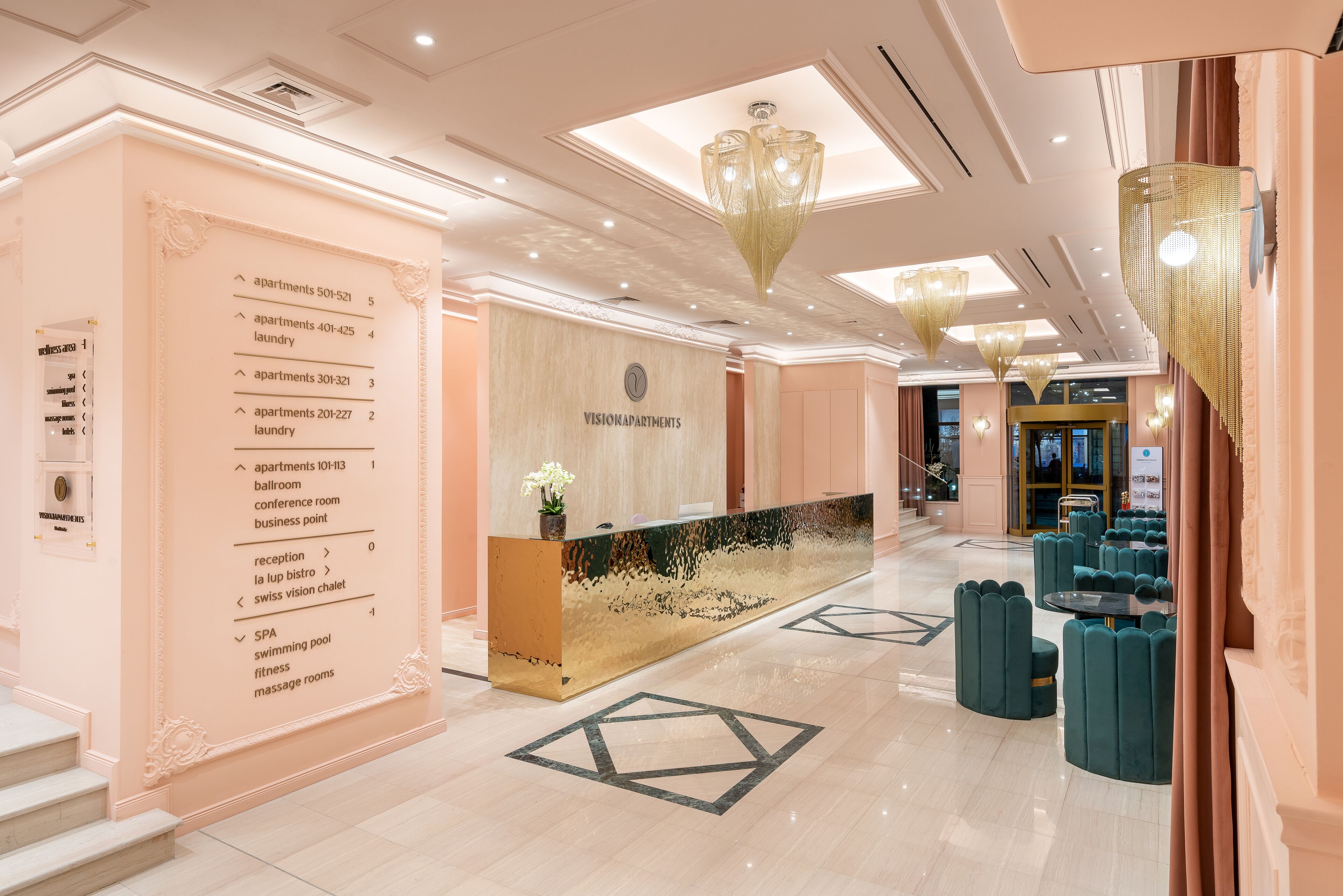 En hotellobby med en receptionsdisk, en informationskiosk till vänster och en sittgrupp med runda bord.