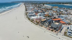 A coastal town with a beach, residential buildings, and a marina.