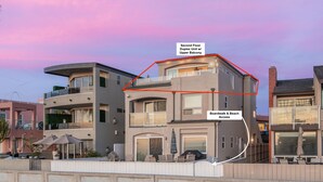 A multi-story building with a second-floor duplex unit featuring an upper balcony, and a backyard with beach access.