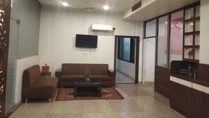 Una sala de estar moderna con un sofá marrón, una mesa de centro y un televisor montado en la pared.