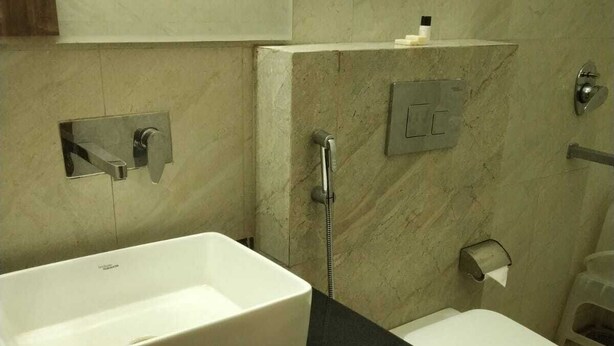 Une salle de bain avec un lavabo blanc, des toilettes et une douche.