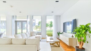 A modern living room with a sofa, coffee table, and a potted plant.