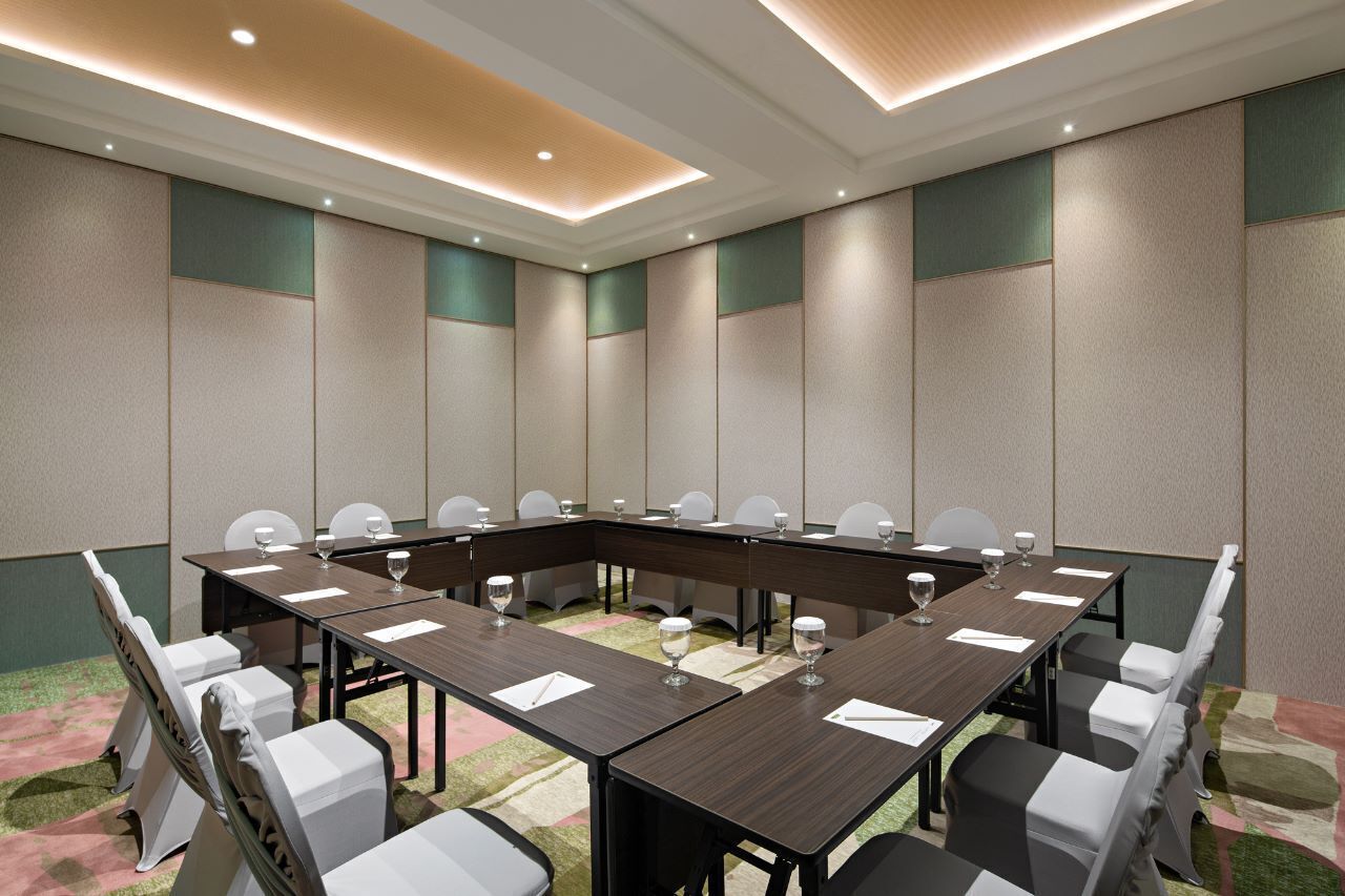 A conference room with a long table, chairs, and glassware.
