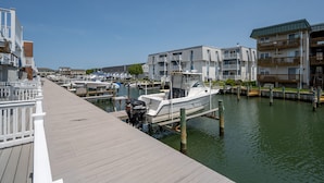 A marina with docked boats, wooden walkways, and modern residential buildings. - Two Bedroom Townhome On Canal! (Ocean City)