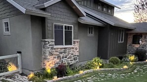 A modern house with a stone facade, a well-maintained lawn, and a stone pathway leading to the entrance. - Luxury Mountain Retreat Near Midway & Park City – Sleeps 10 (Heber City)