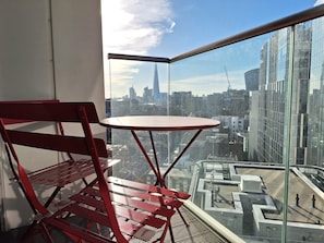 Enjoy a city view from the comfort of this room, featuring a large window and a stylish metal chair.
