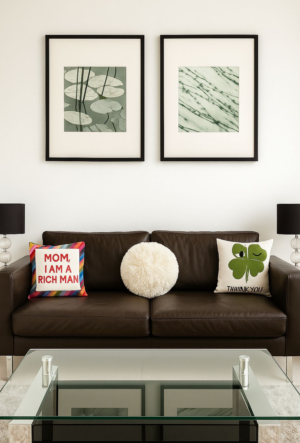 A brown leather sofa with two cushions, a glass coffee table, and two framed artworks above.