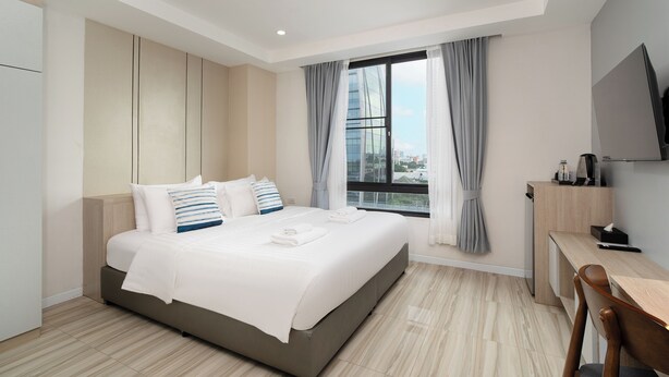 A modern hotel room with a large bed, a desk, and a TV. - The Riski Hotel at Bangphlat Station (Bangkok)