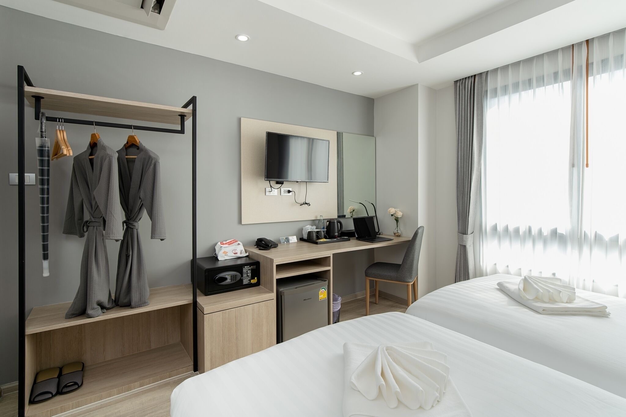 Ein modernes Hotelzimmer mit Bett, Schreibtisch und Kleiderschrank.